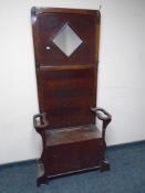 A 20th century oak mirrored hall stand with storage seat.