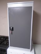 A metal storage cabinet with key.