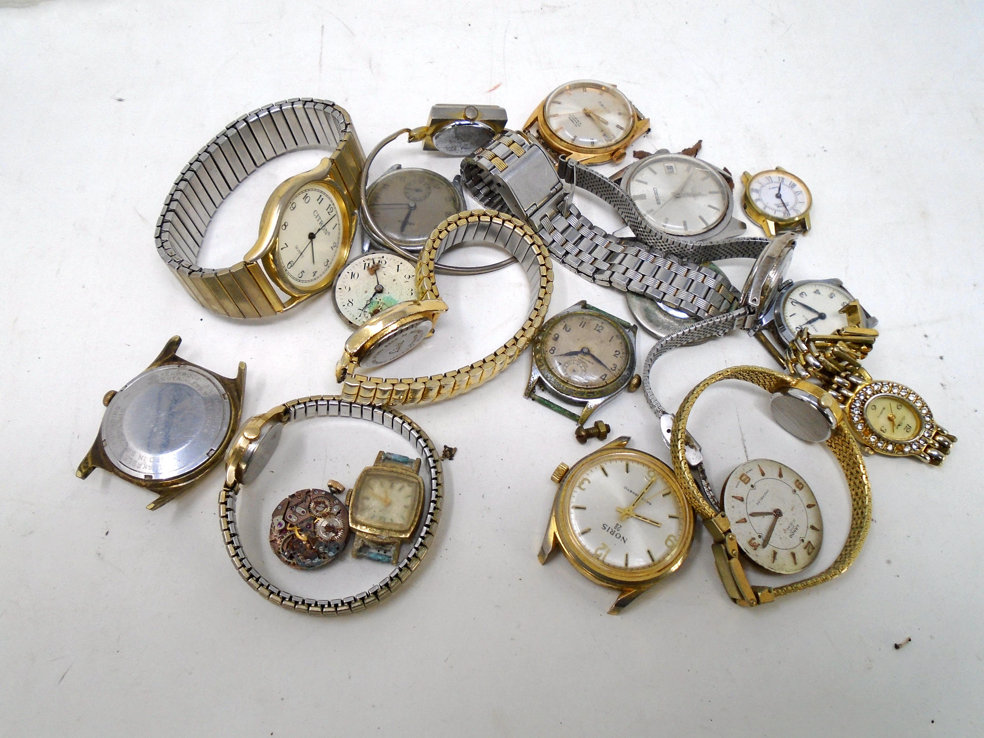 A tub containing assorted lady's and gent's wristwatches, watch movements.