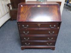 An inlaid writing bureau fitted with four drawers in mahogany finish.