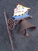 A cast iron tall ship wall bracket with bell.