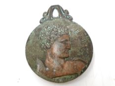 A bronze clip depicting a Greek figure.