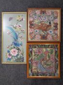 A framed needlework panel depicting a bird of paradise together with two further framed tapestries