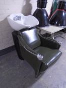 A green stitched leather hairdresser's chair with sink tap and sprayer.