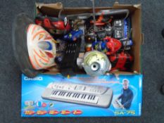A box containing a quantity of assorted remote control cars together with a Casio SA-75 keyboard.