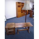 A 20th century three tier book table together with a refectory coffee table and standard lamp with