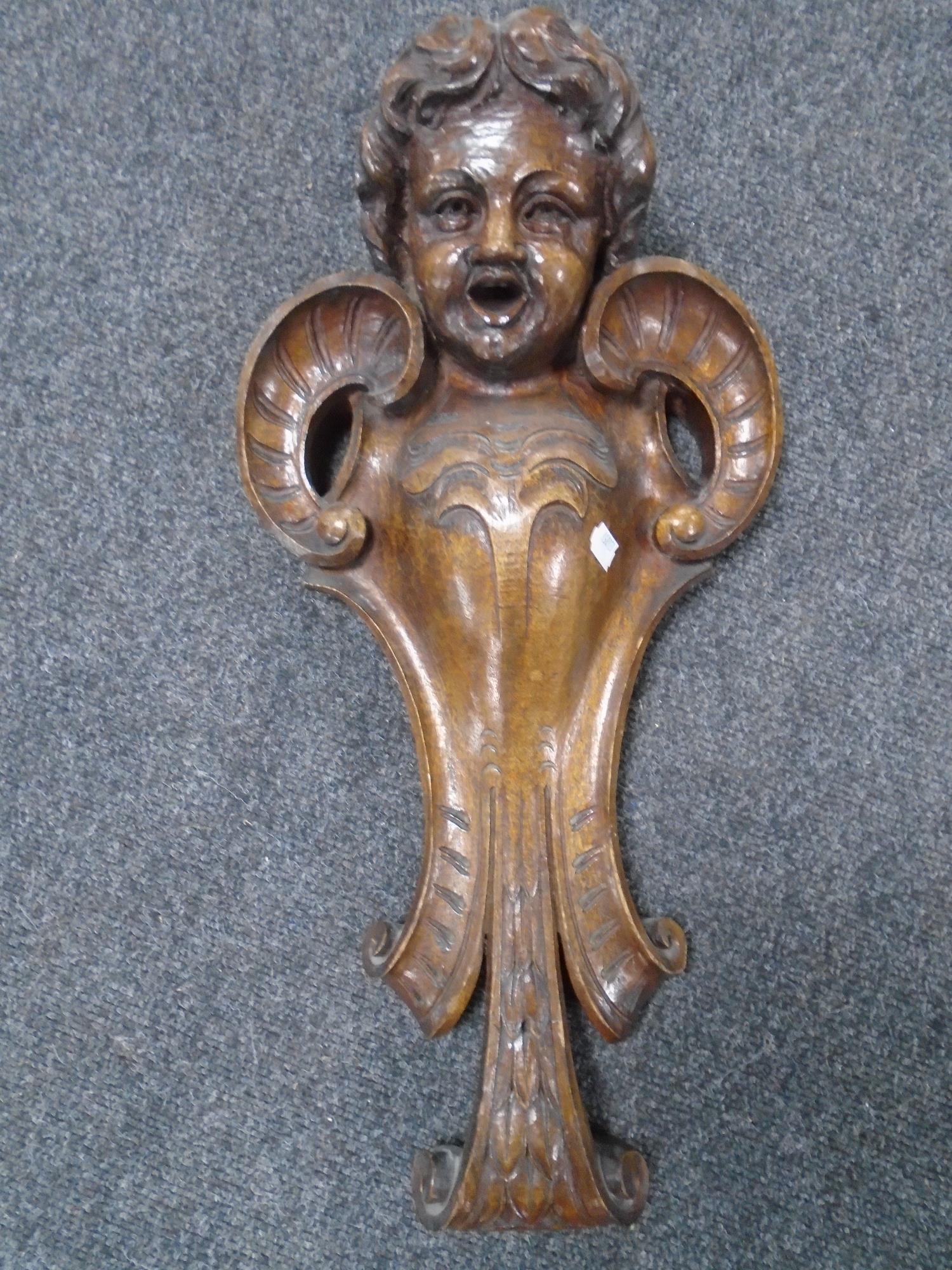 A carved cherub wall sconce,