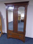 An Edwardian double door mirrored wardrobe with fitted drawer beneath.