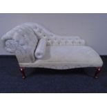 A reproduction miniature chaise longue in classical floral fabric