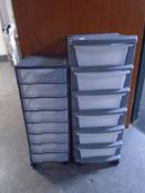 Two plastic multi-drawer storage chests on castors.