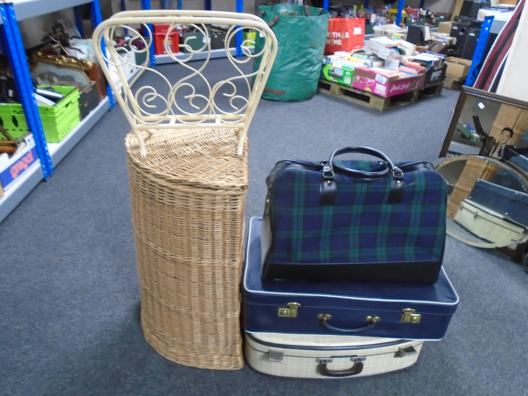 A wicker corner basket containing wooden blankets together with a wrought iron magazine rack,