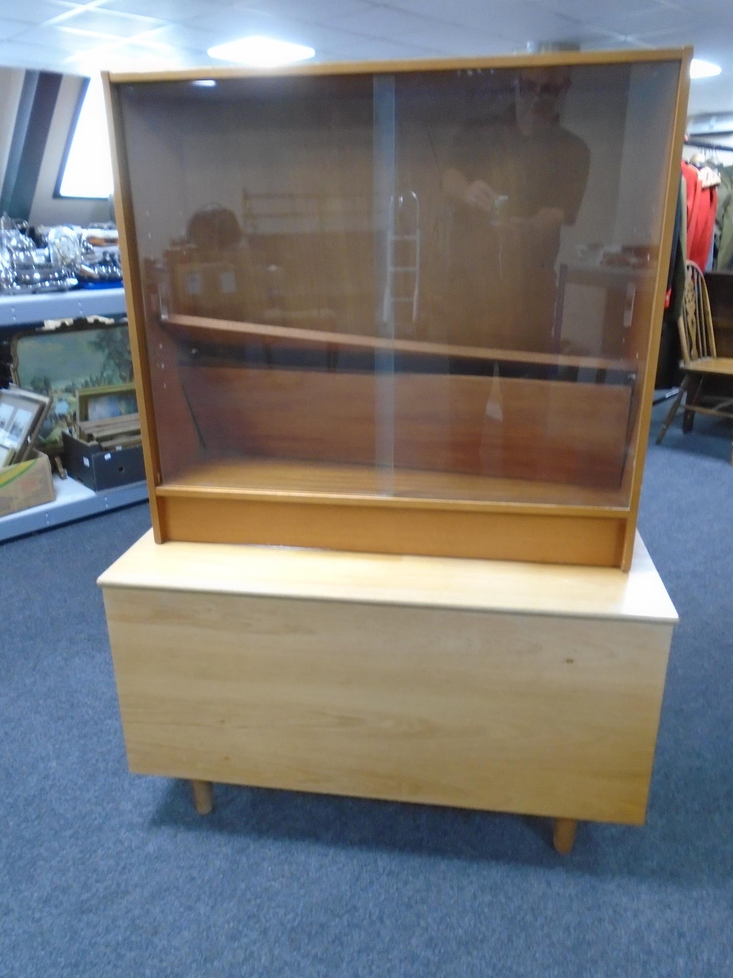 A 20th century teak storage blanket box together with a set of teak sliding glass door bookshelves