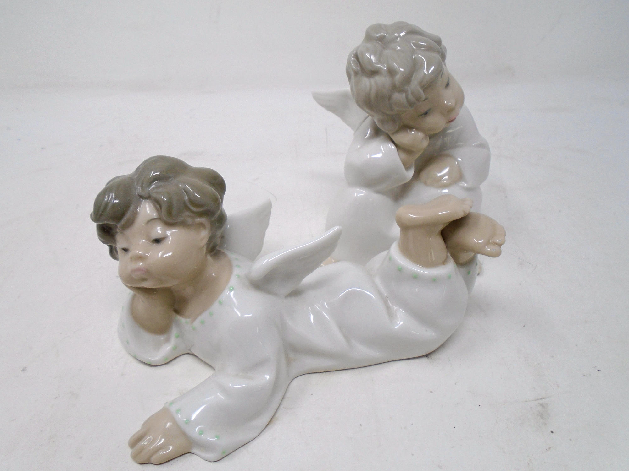 Two Lladro figures of cherubs.