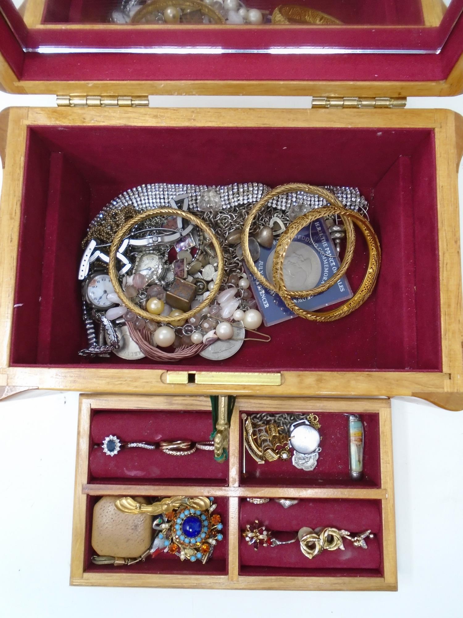 A jewellery casket on raised feet with lift out tray containing a collection of assorted costume