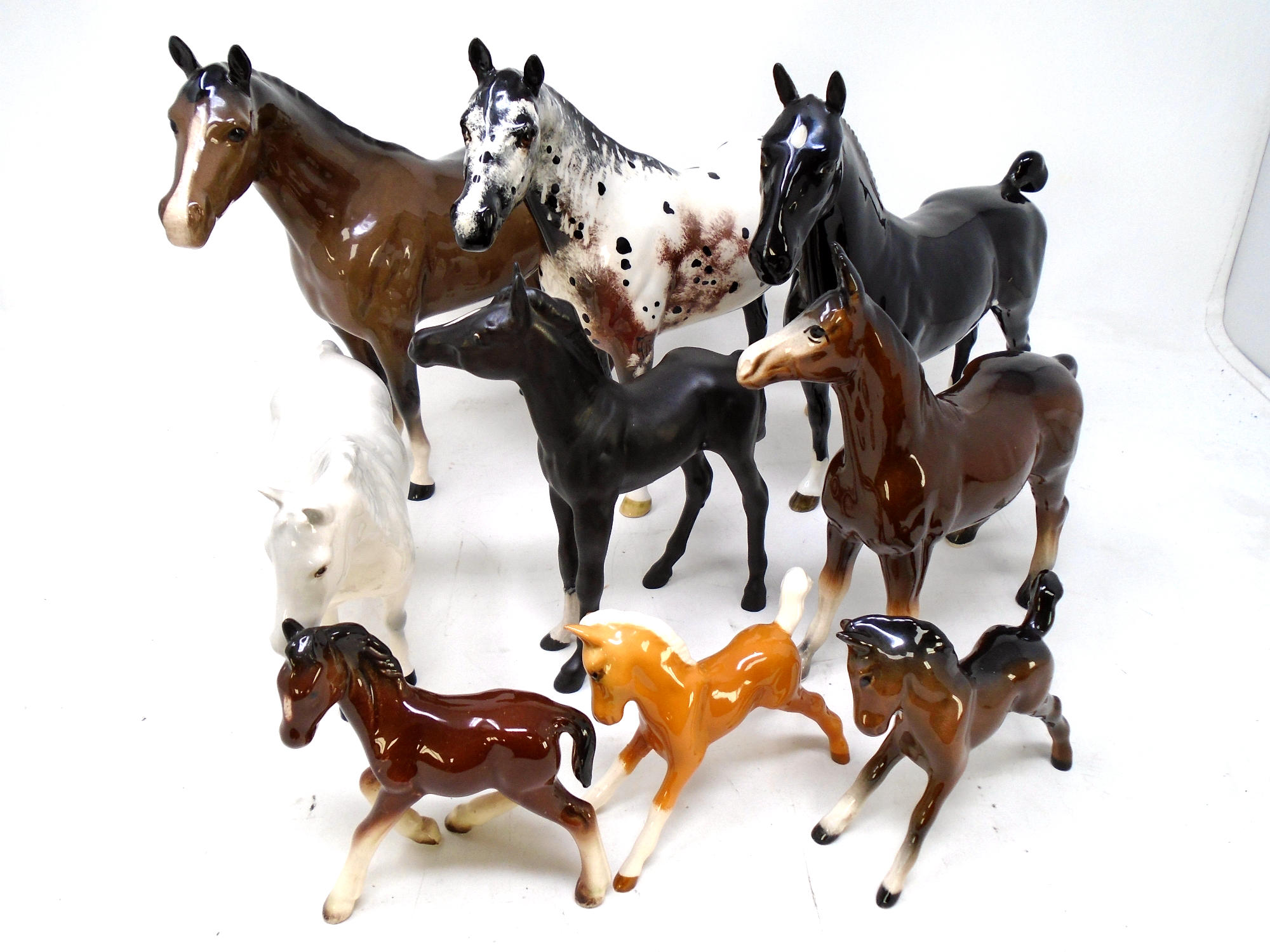 A tray containing nine ceramic horses including Beswick examples.