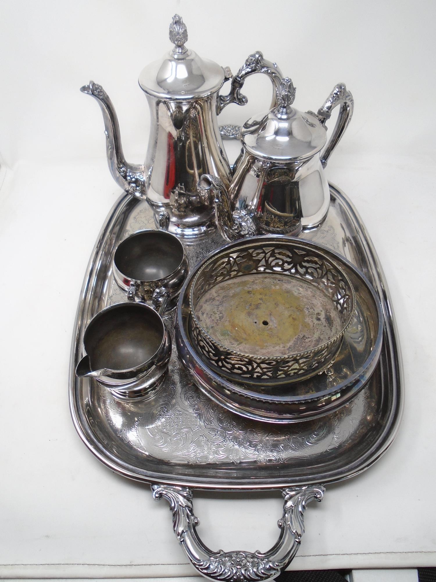 A silver plated twin handle serving tray together with a four piece tea service,