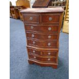 A miniature serpentine fronted eight drawer chest