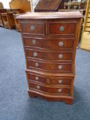 A miniature serpentine fronted eight drawer chest