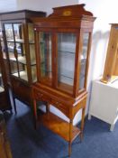 A Bradley inlaid yew wood double door display cabinet on table.