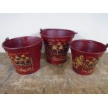 A set of three graduated metal buckets bearing Coca-cola advertising.