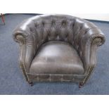 An Alexander & James buttoned and studded leather tub armchair.