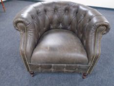 An Alexander & James buttoned and studded leather tub armchair.