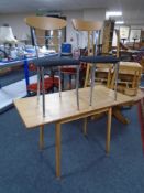 A drop leaf kitchen table together with a pair of Effezeta dining chairs on tubular metal legs.