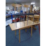 A drop leaf kitchen table together with a pair of Effezeta dining chairs on tubular metal legs.