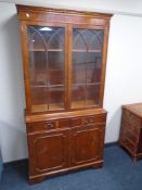 A yew wood glazed double door bookcase fitted with cupboards and drawers beneath,