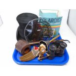A tray containing antique field glasses, top hat, Polaroid camera, rustic pipe etc.