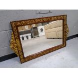 A decorative mahogany and brass framed wall mirror.