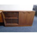 A 20th century teak sliding glass door bookcase fitted with a double door cupboard,