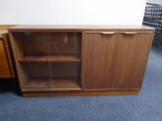 A 20th century teak sliding glass door bookcase fitted with a double door cupboard,