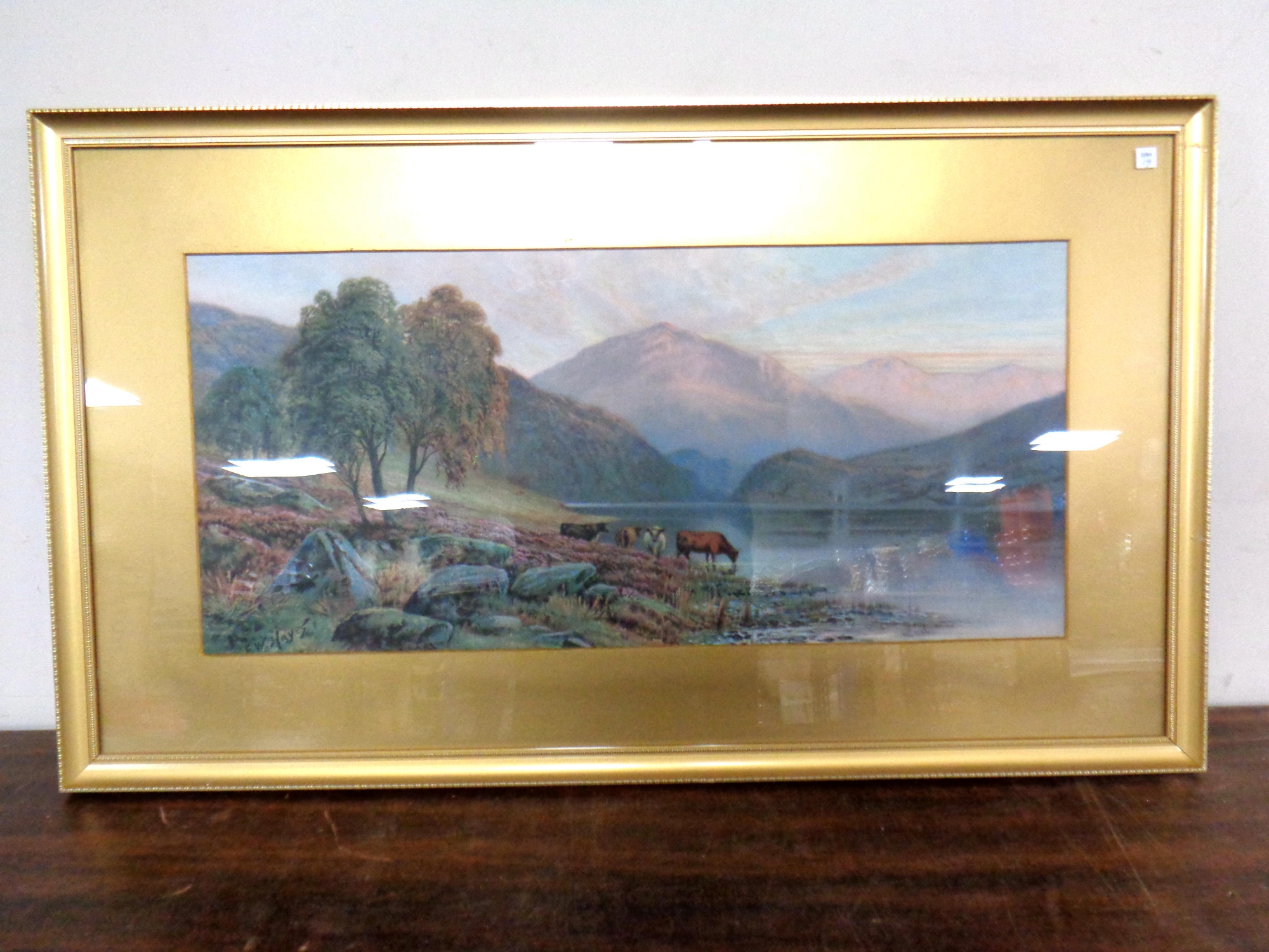 E. W. Hayes : Highland Cattle by a Loch, watercolour, signed, 54cm by 25cm.