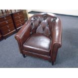 A Thomas Lloyd brown buttoned leather tub armchair.