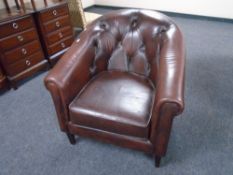 A Thomas Lloyd brown buttoned leather tub armchair.