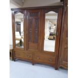 A 19th century mahogany triple door wardrobe fitted with mirrors and two drawers beneath,