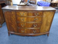 A mahogany bow fronted double door sideboard fitted with four central drawers and brass drop