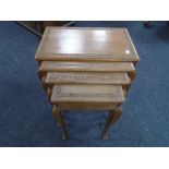 A nest of four carved Indian style tables, one fitted with a drawer.