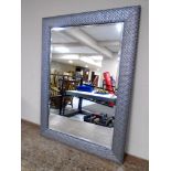 A contemporary overmantel bevel edged mirror in frame.