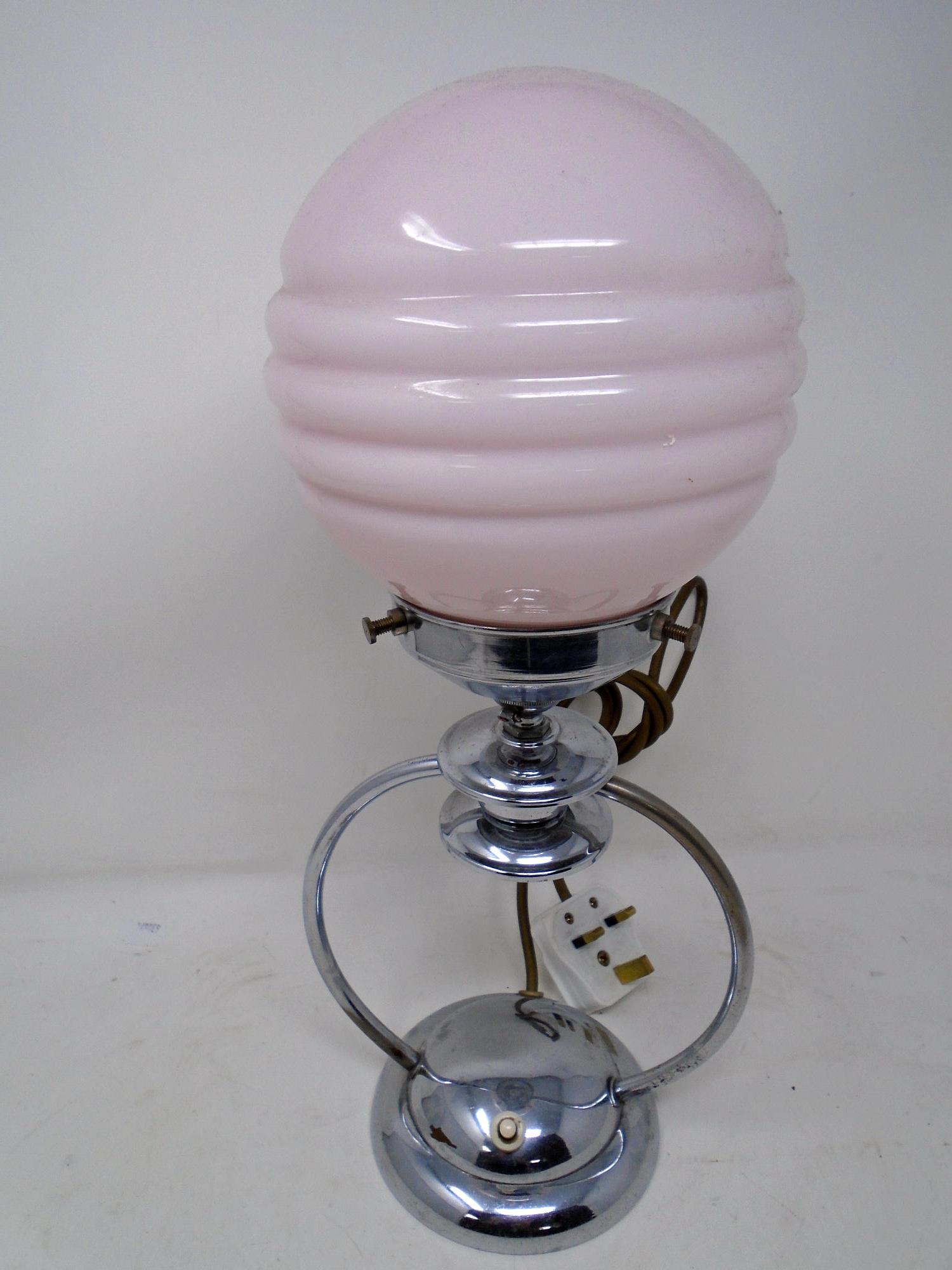 A chrome Art Deco table lamp with pink glass shade (height 38cm).