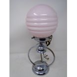 A chrome Art Deco table lamp with pink glass shade (height 38cm).