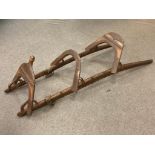 An antique Mahawi (camel saddle), iron enforced curved wooden rails with leather toggles,