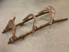 An antique Mahawi (camel saddle), iron enforced curved wooden rails with leather toggles,