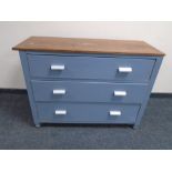 A wooden-topped painted three drawer chest.