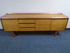 A mid-20th century Scandinavian low double door sideboard fitted with three drawers together with