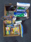 Two boxes containing new novelty toys, golf putting mat and chipping game etc.