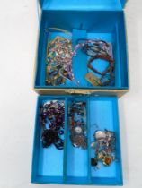 A jewellery box with key containing a small quantity of costume jewellery including beaded