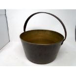 An antique brass jam pan with cast iron handle.