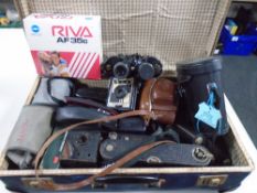 A vintage luggage case containing Boots Fleet 15x35 binoculars, assorted vintage cameras.